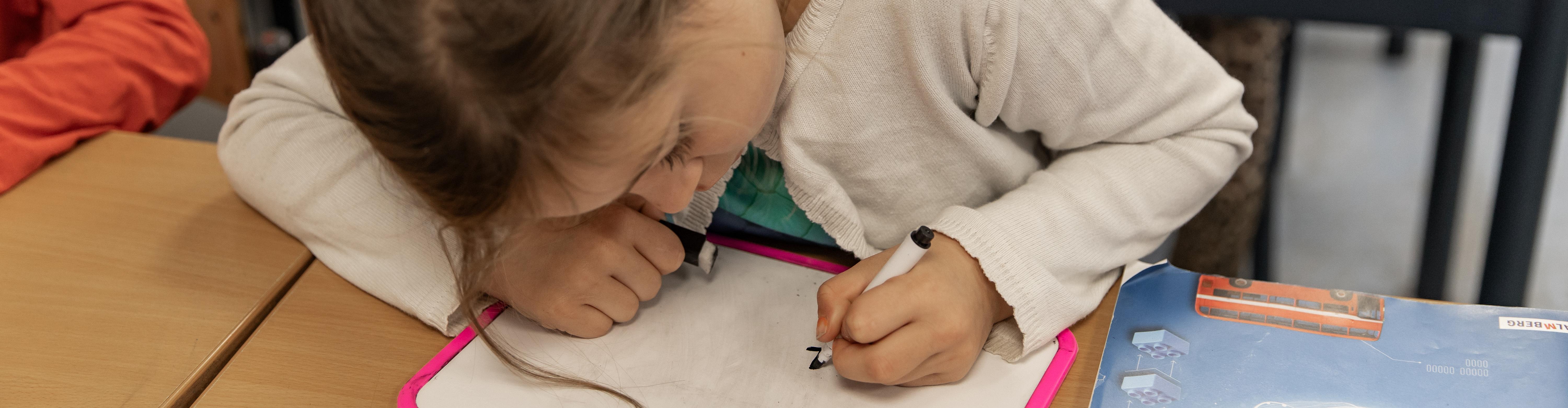 kind schrijft op wisbord basisschool dik trom