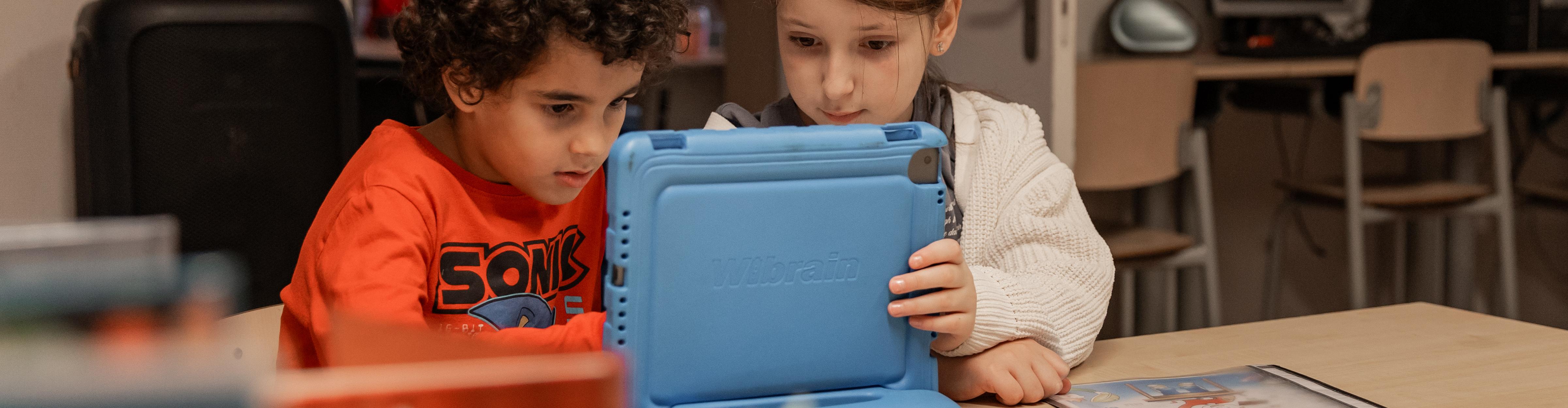 2 kinderen werken samen op de tablet