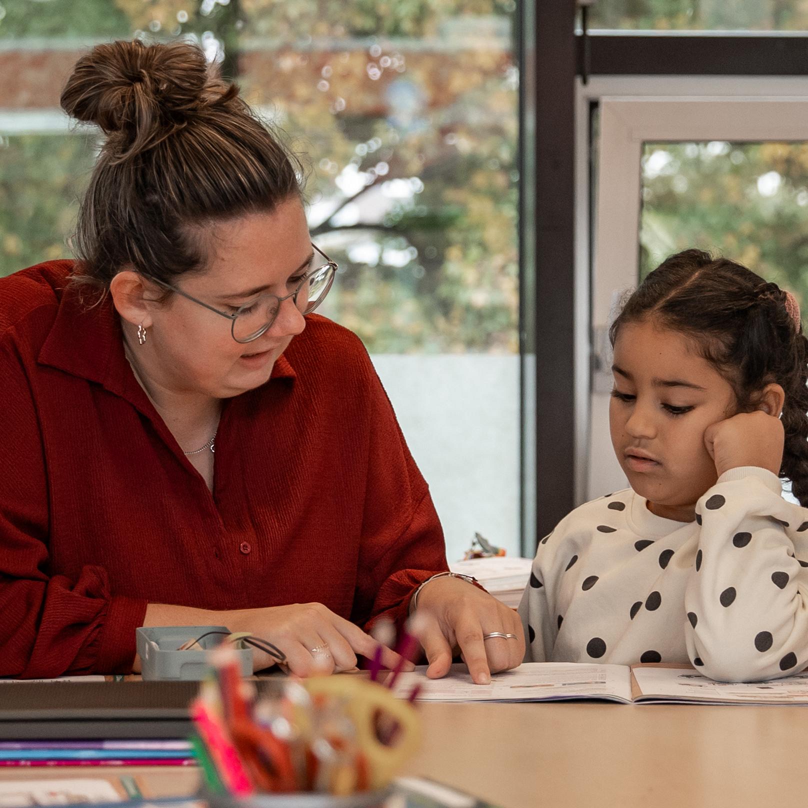Leerkracht legt uit aan leerling 